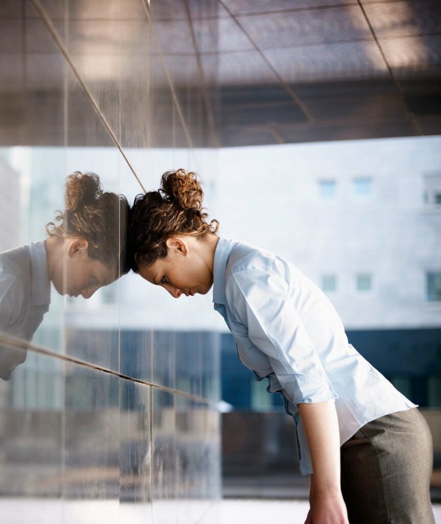Woman banging head against wall in frustration